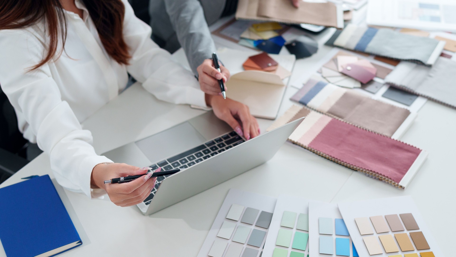 Interior Design Consultation Asian Women Architects Planning Project on Laptop with Paint and Fabric Samples for Home Renovation Color Scheme Ideas